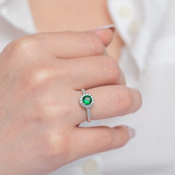 Silver ring with a central round stone of emerald colored zirconia